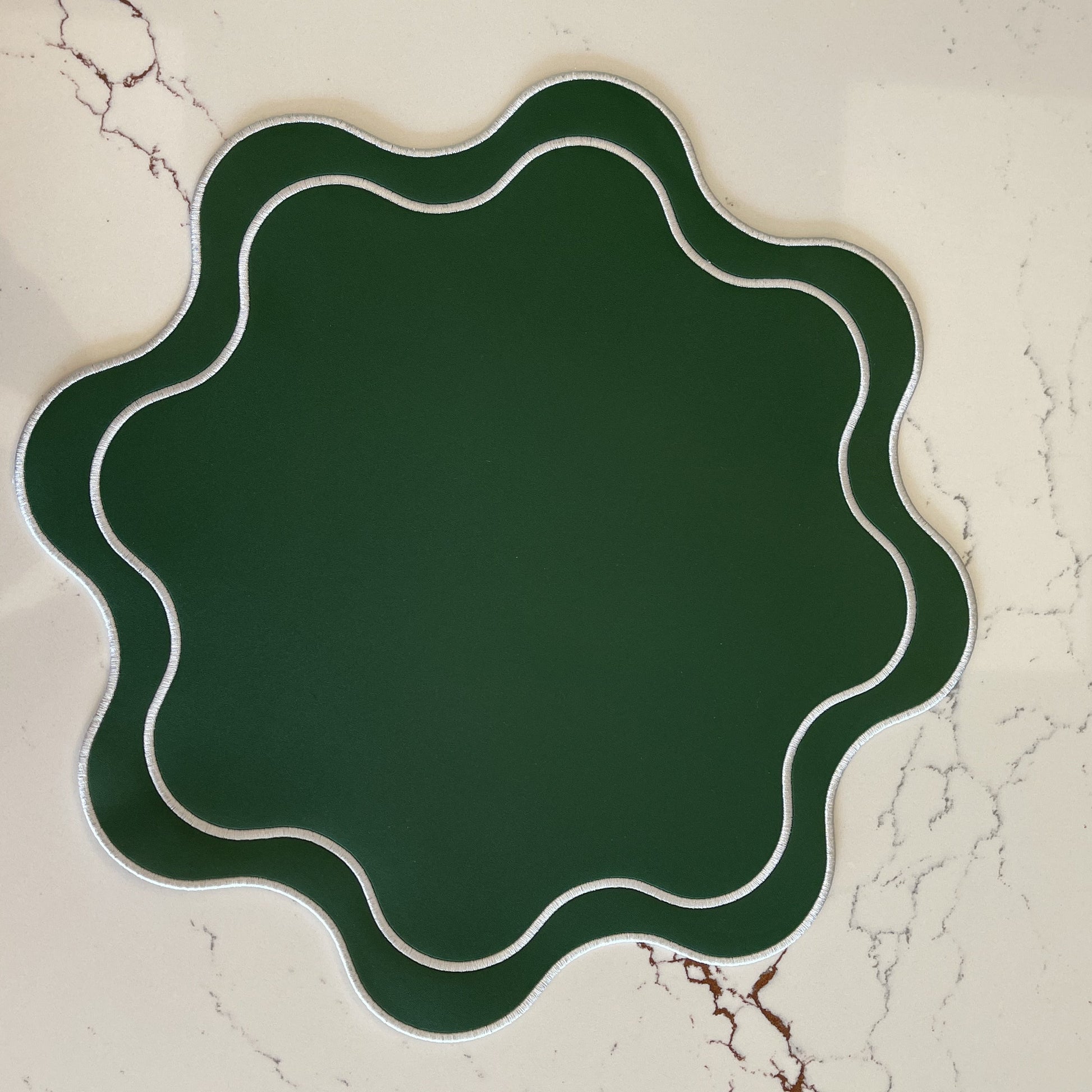 Decorative green plate with wavy edge on a textured beige background