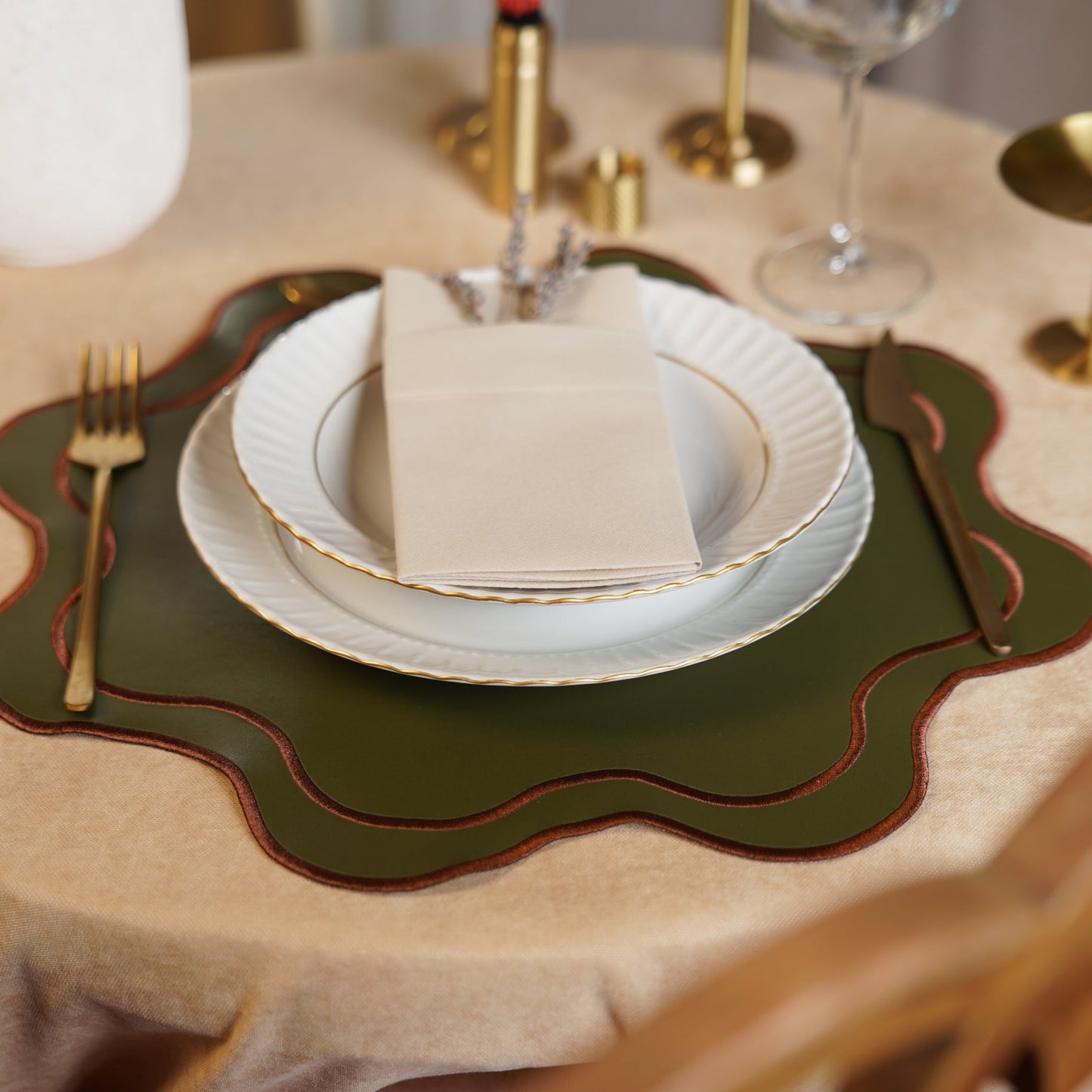 Dining table setting with plates, cutlery, and a decorative placemat.