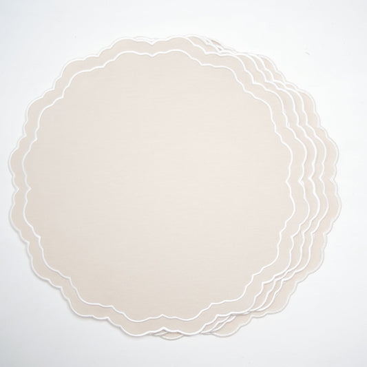 Set of round beige placemats with scalloped edge on a white background