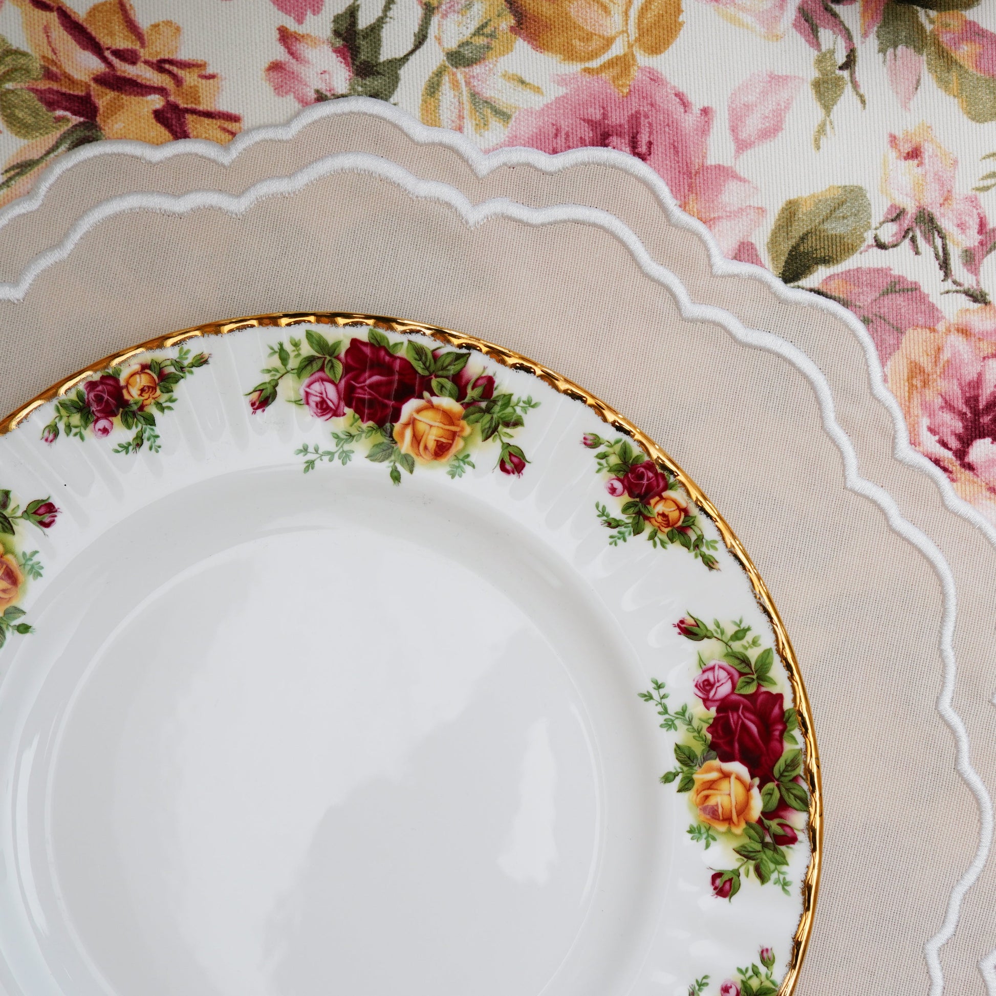 Floral-patterned tablecloth with white plates and gold knife.