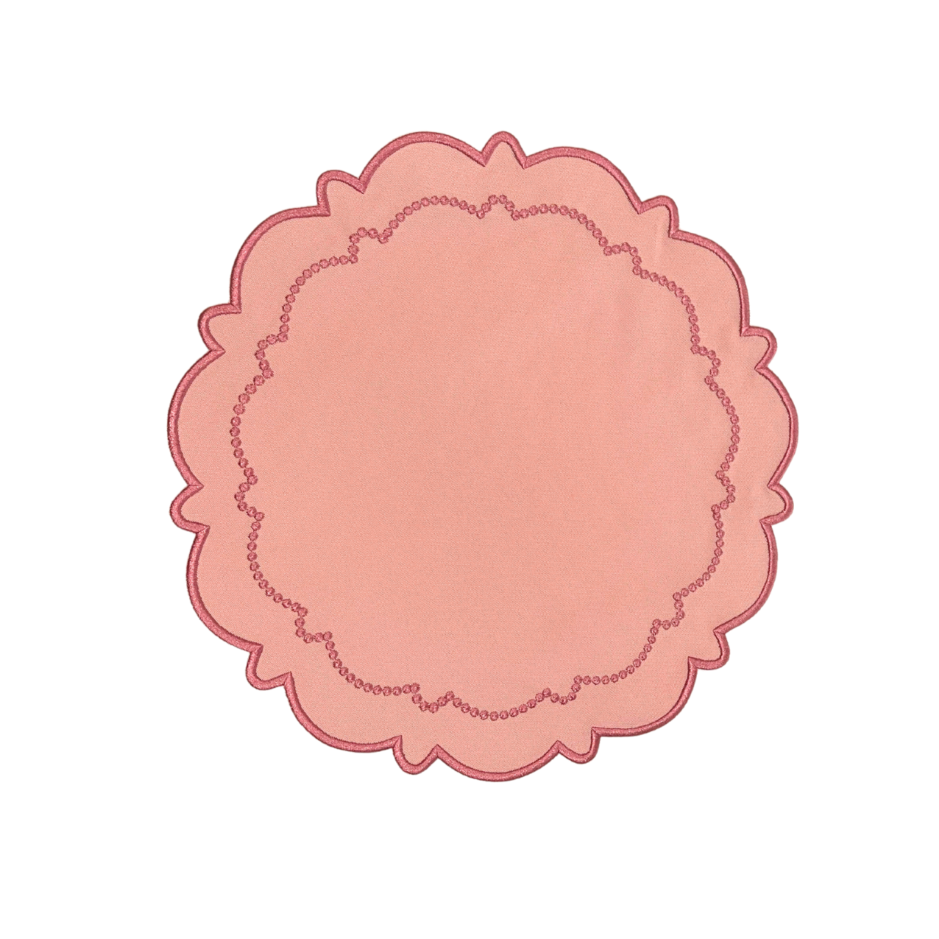 A round pink fabric placemat with a scalloped edge on a white background.