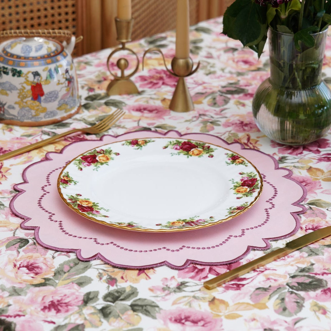 Elegant table setting with floral tablecloth and plates.