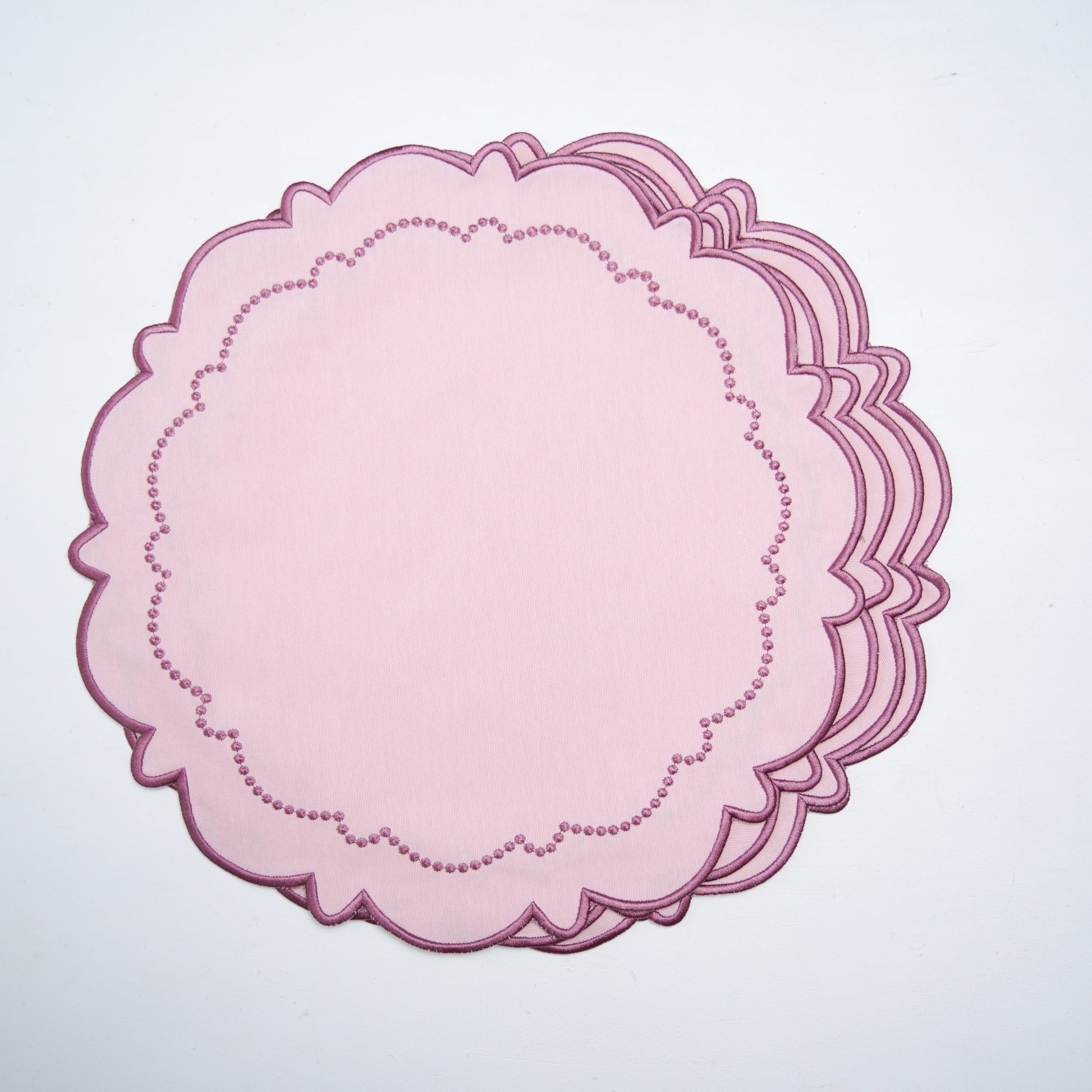 Pink scalloped paper cutout on a white background
