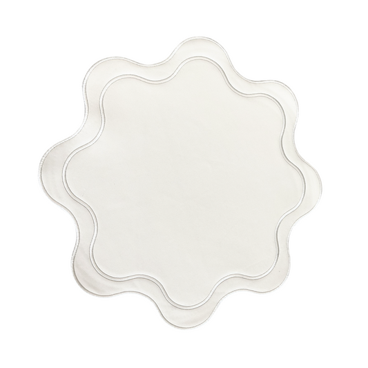 A round white faux leather placemat with a textured surface and decorative stitching.