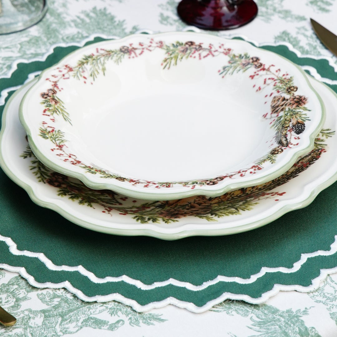 Elegant table setting with decorative plates and cutlery on a patterned tablecloth.
