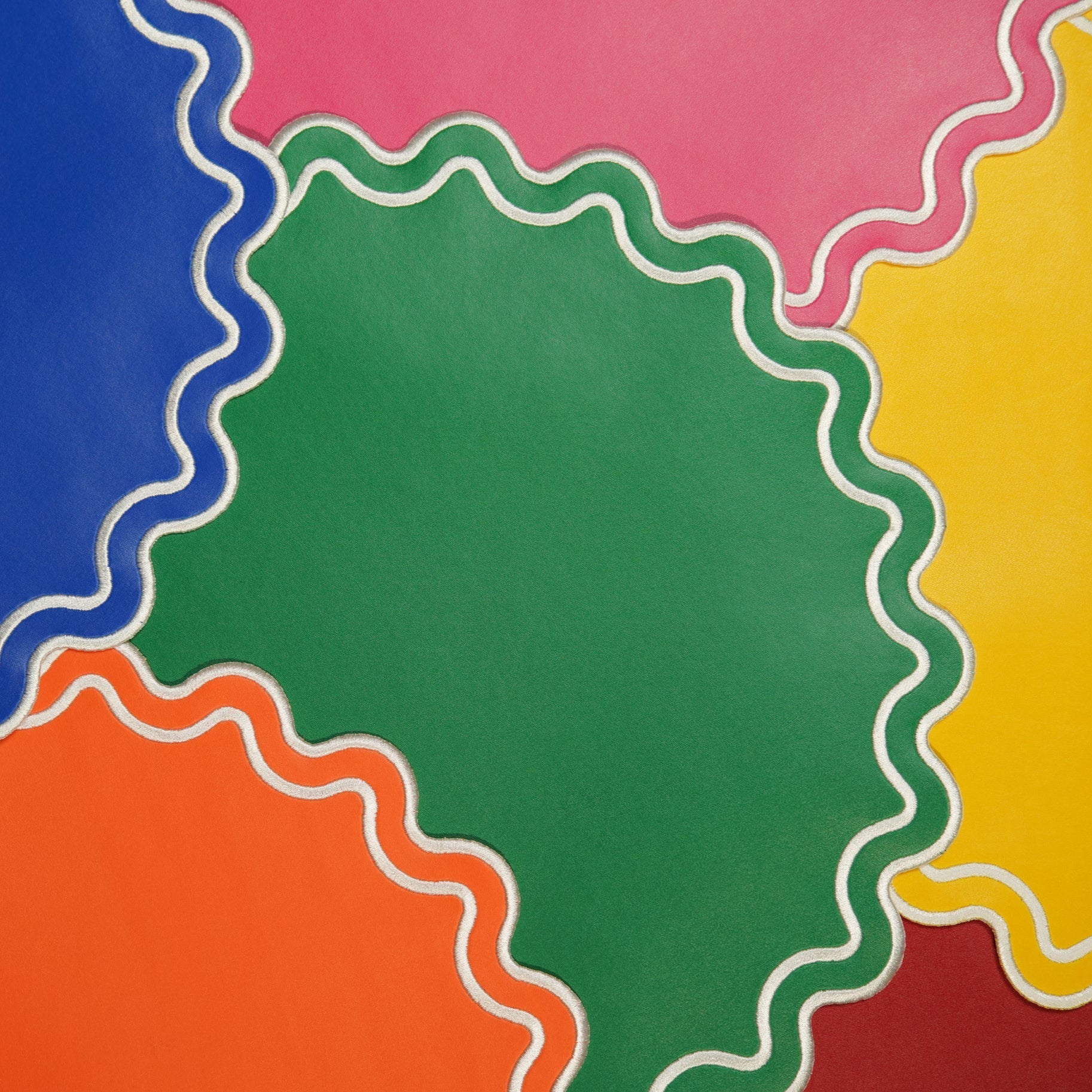 Colorful circular cutouts with wavy edges on a pink background