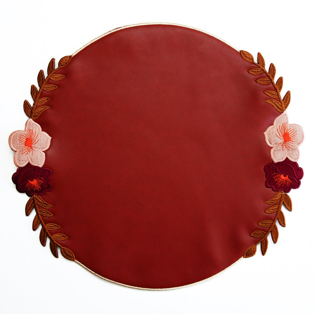 Round red plate with floral decorations on a white background