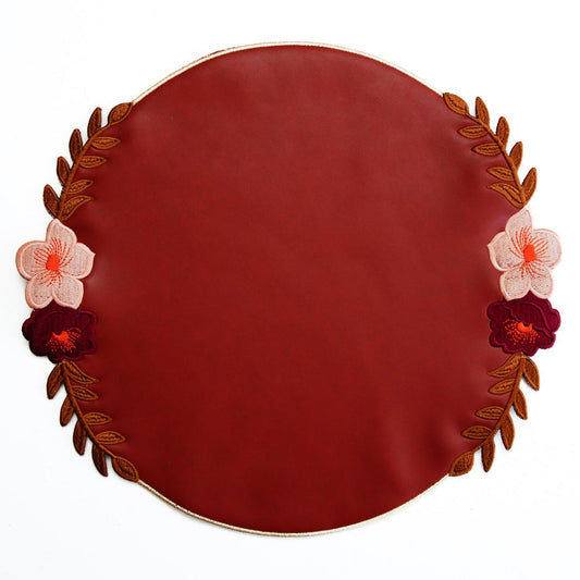 Round red plate with floral decorations on a white background