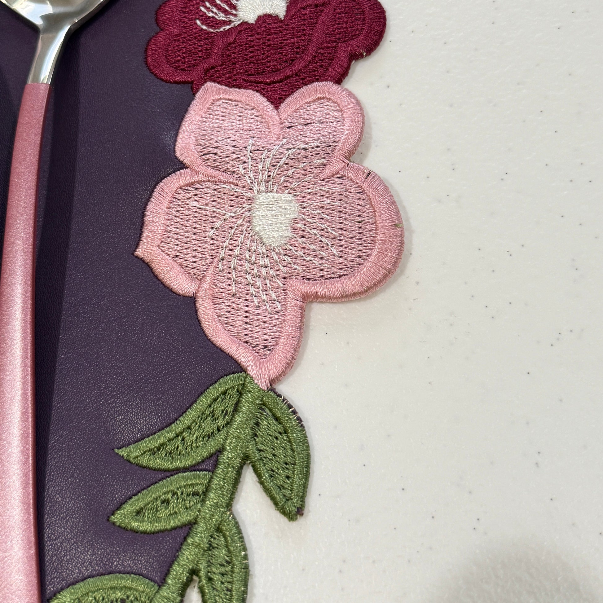 Decorative floral design on a purple background with a spoon.