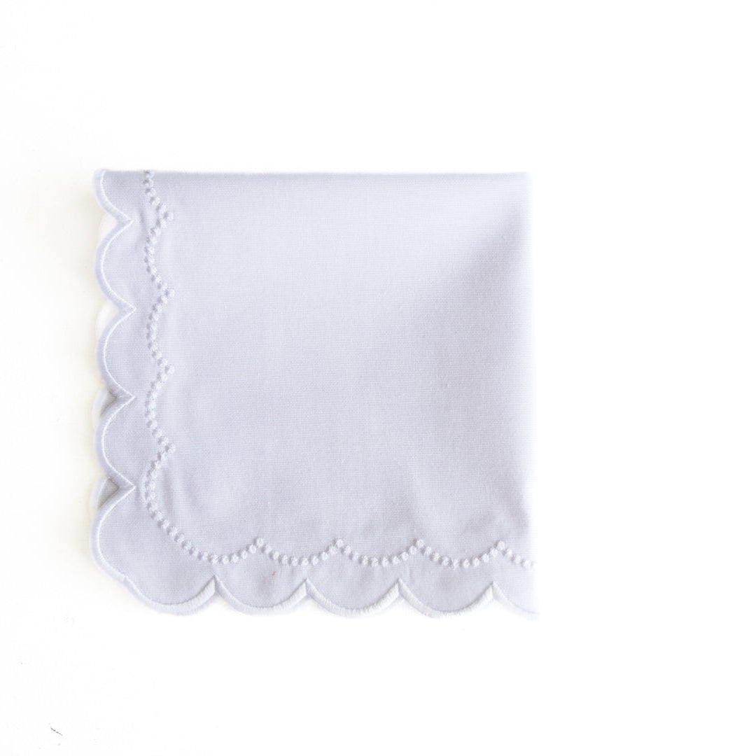 White scalloped edge handkerchief on a white background