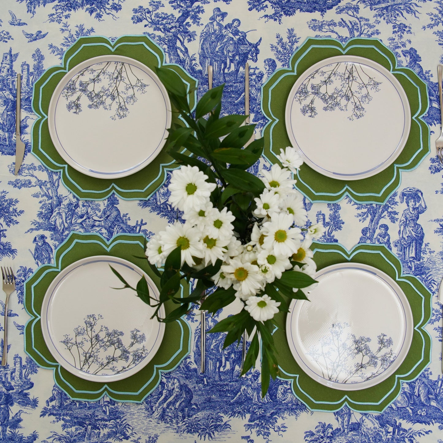 Set of plates on a decorative tablecloth with floral arrangement