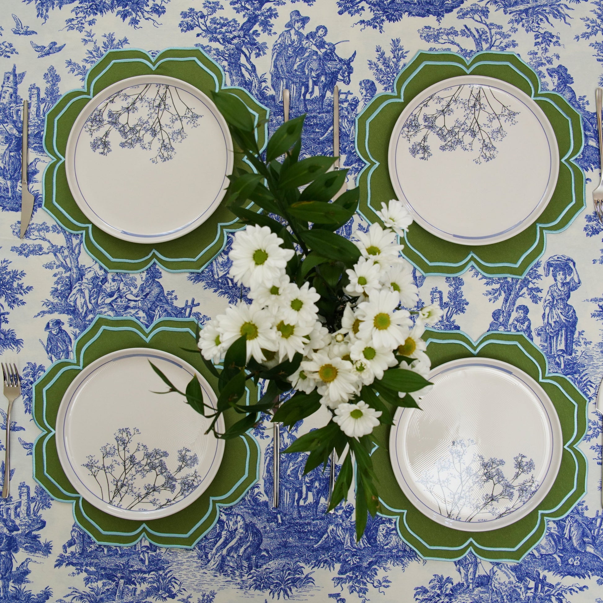 Set of plates on a decorative tablecloth with floral arrangement