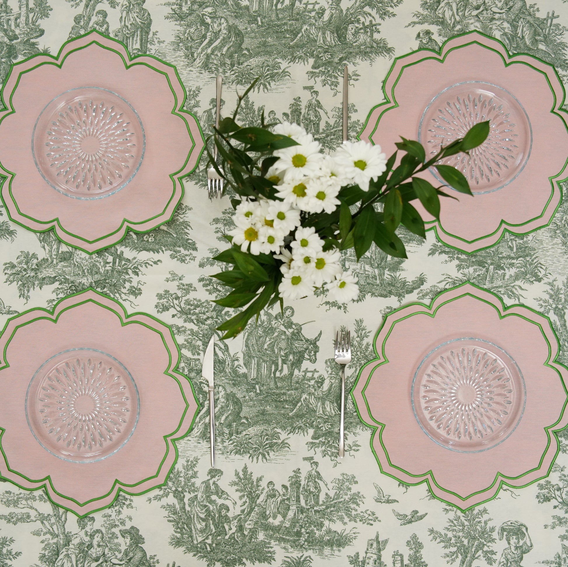 Floral tablecloth with pink flower patterns and a bouquet of flowers on a green and white patterned background.