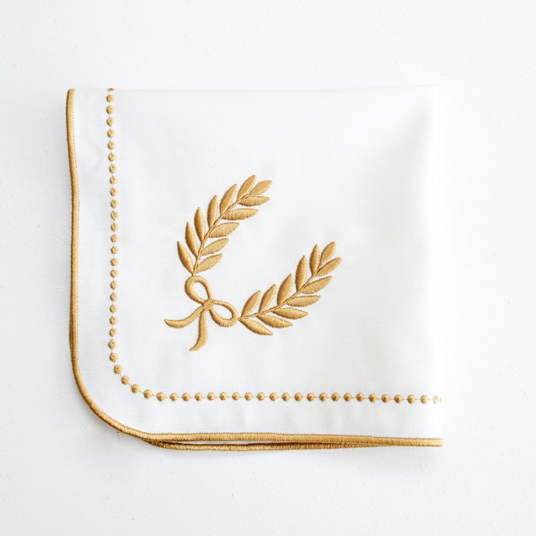 White napkin with gold embroidery on a white background