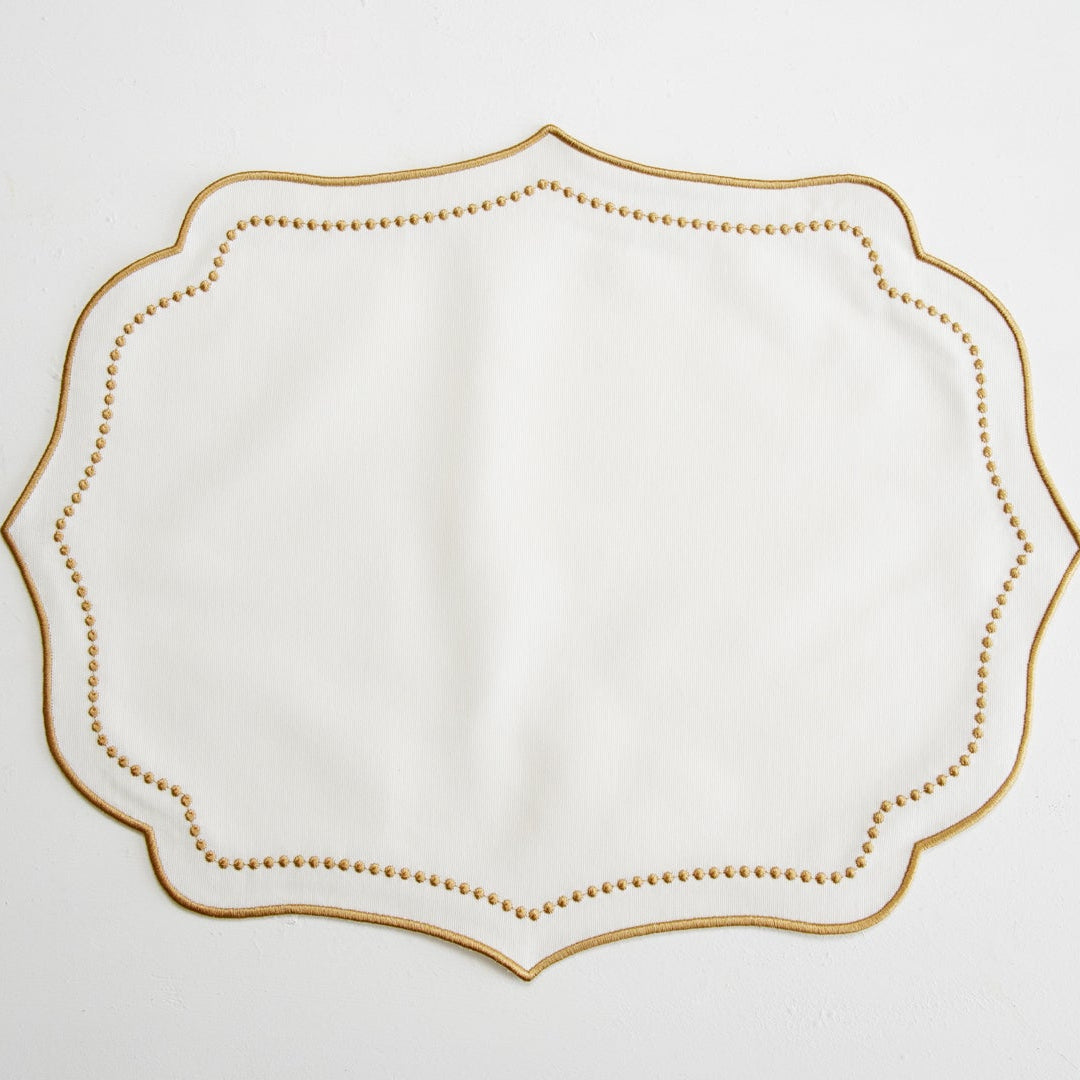 Decorative white napkin with gold border on a light gray background