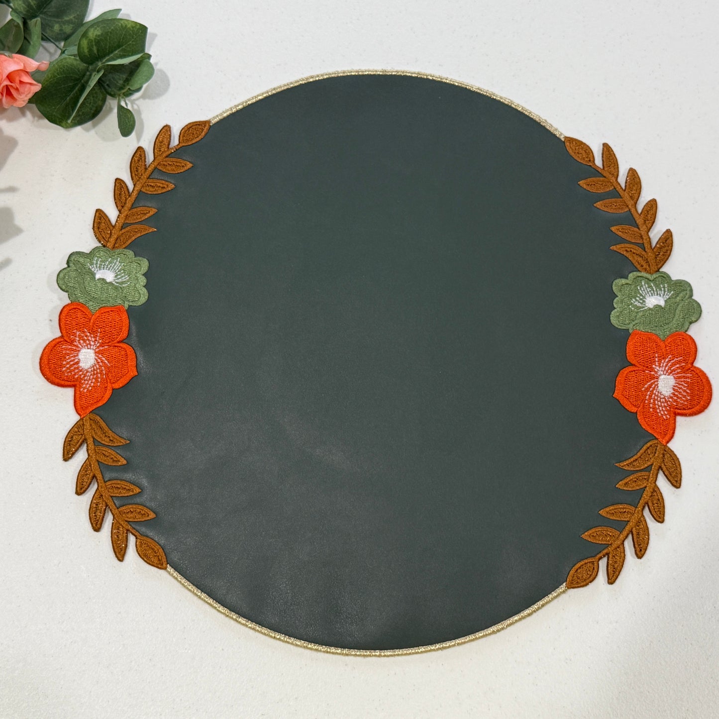 Decorative round plate with floral and leaf design on a white background