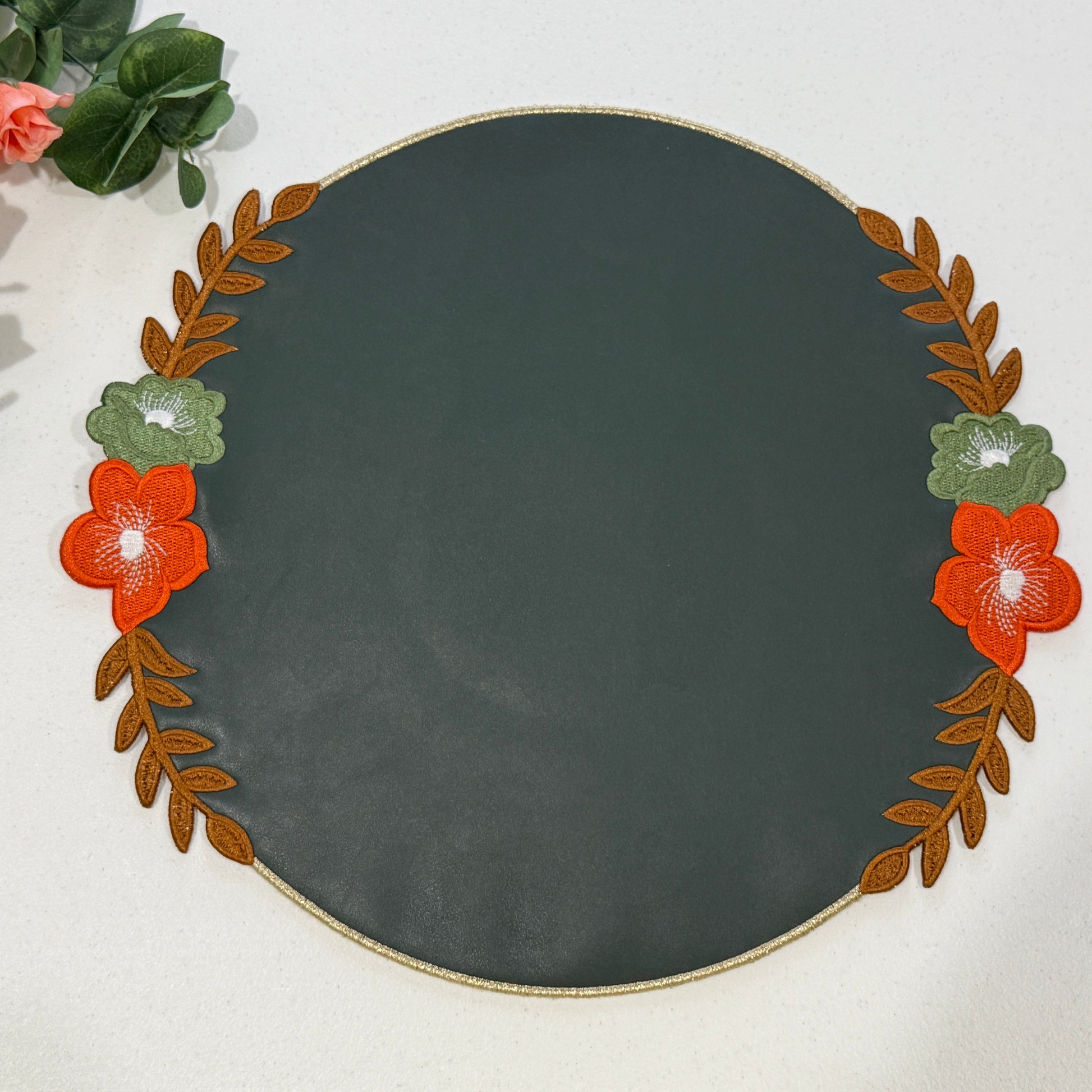 Decorative round plate with floral and leaf design on a white background