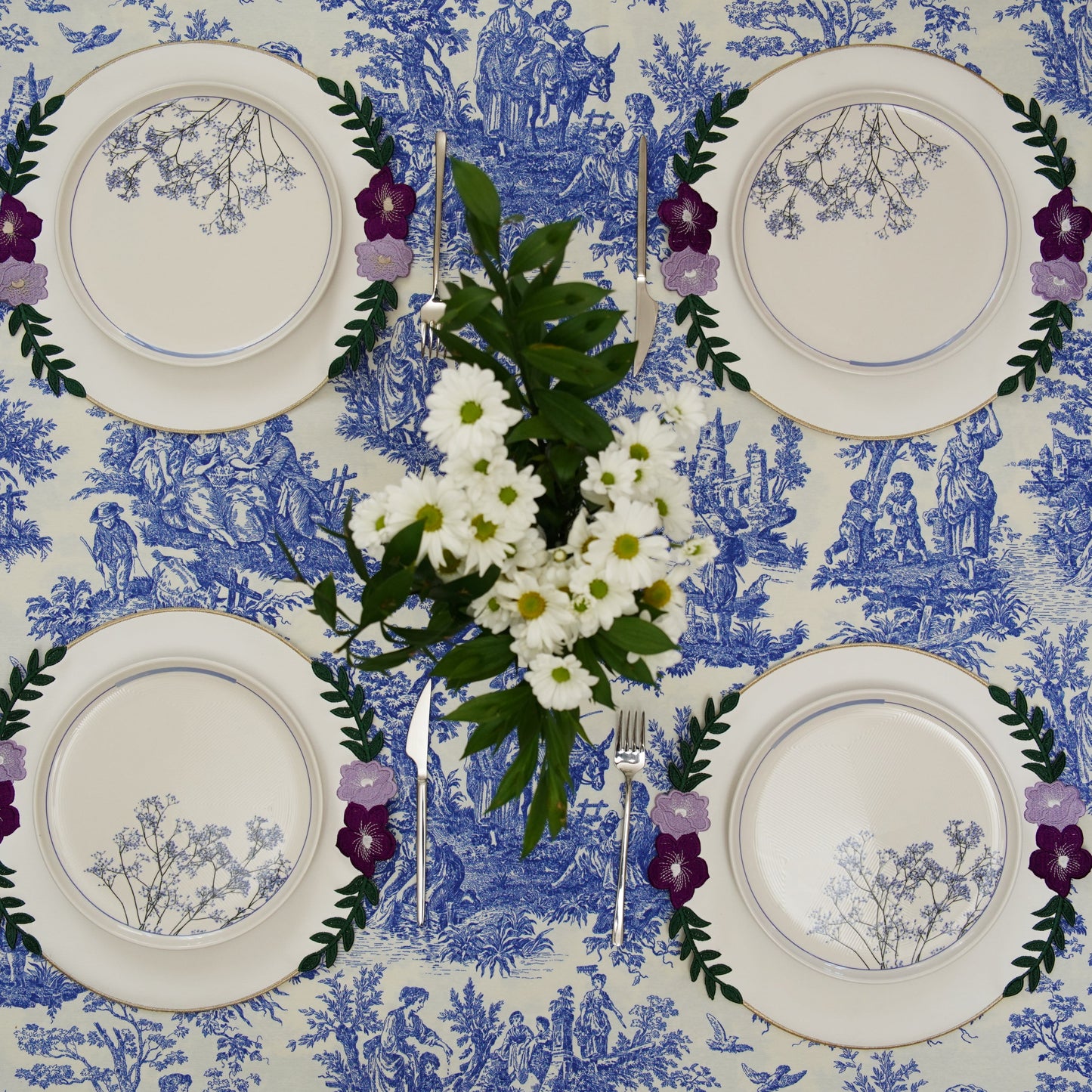 Set table with floral decorations on a blue and white patterned tablecloth