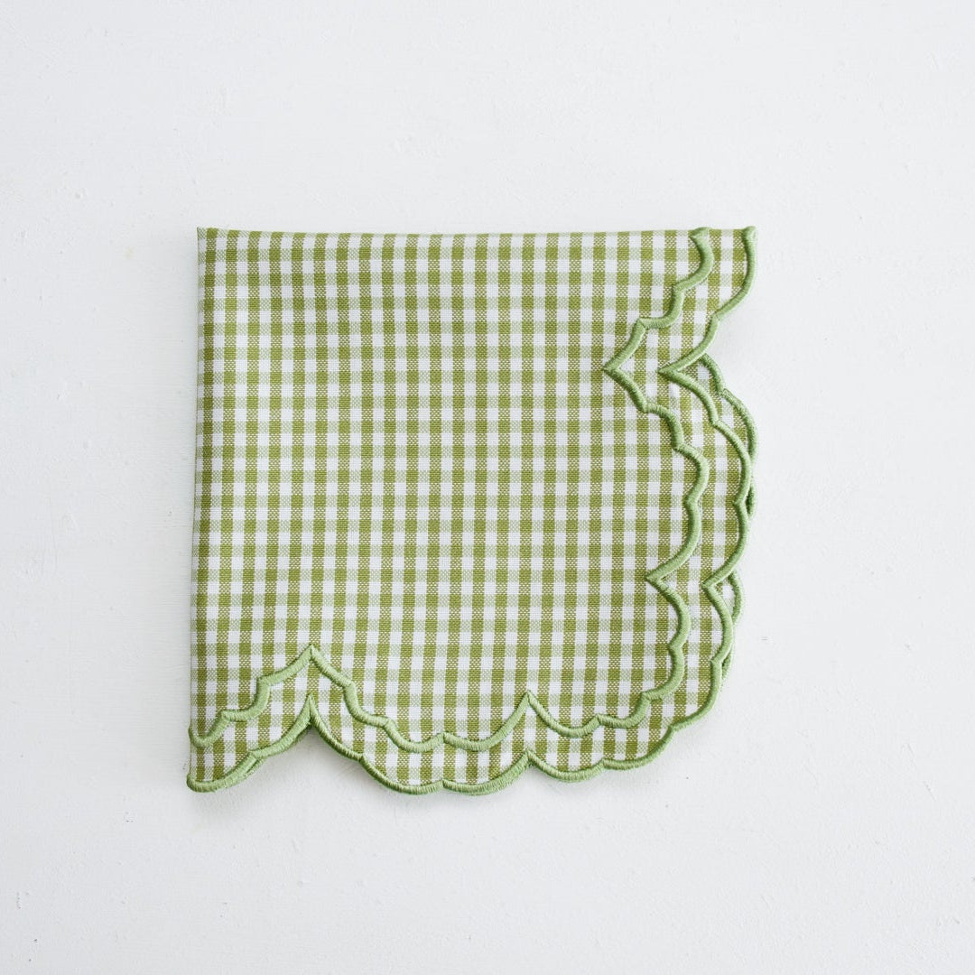 Green checkered fabric with scalloped edge on a white background
