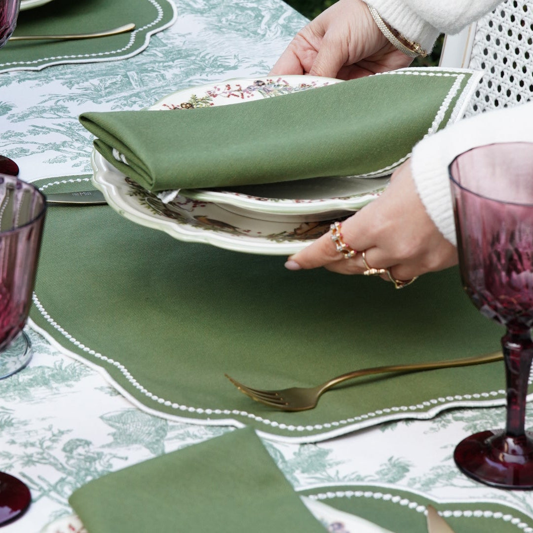 Table setting with green napkins and purple glasses.