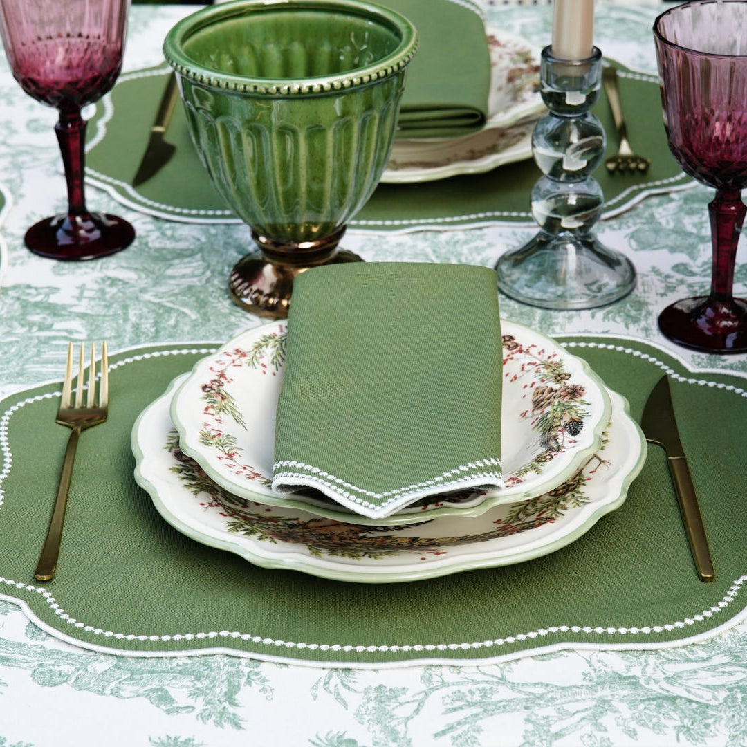 Elegant table setting with green and purple glasses and place mats.