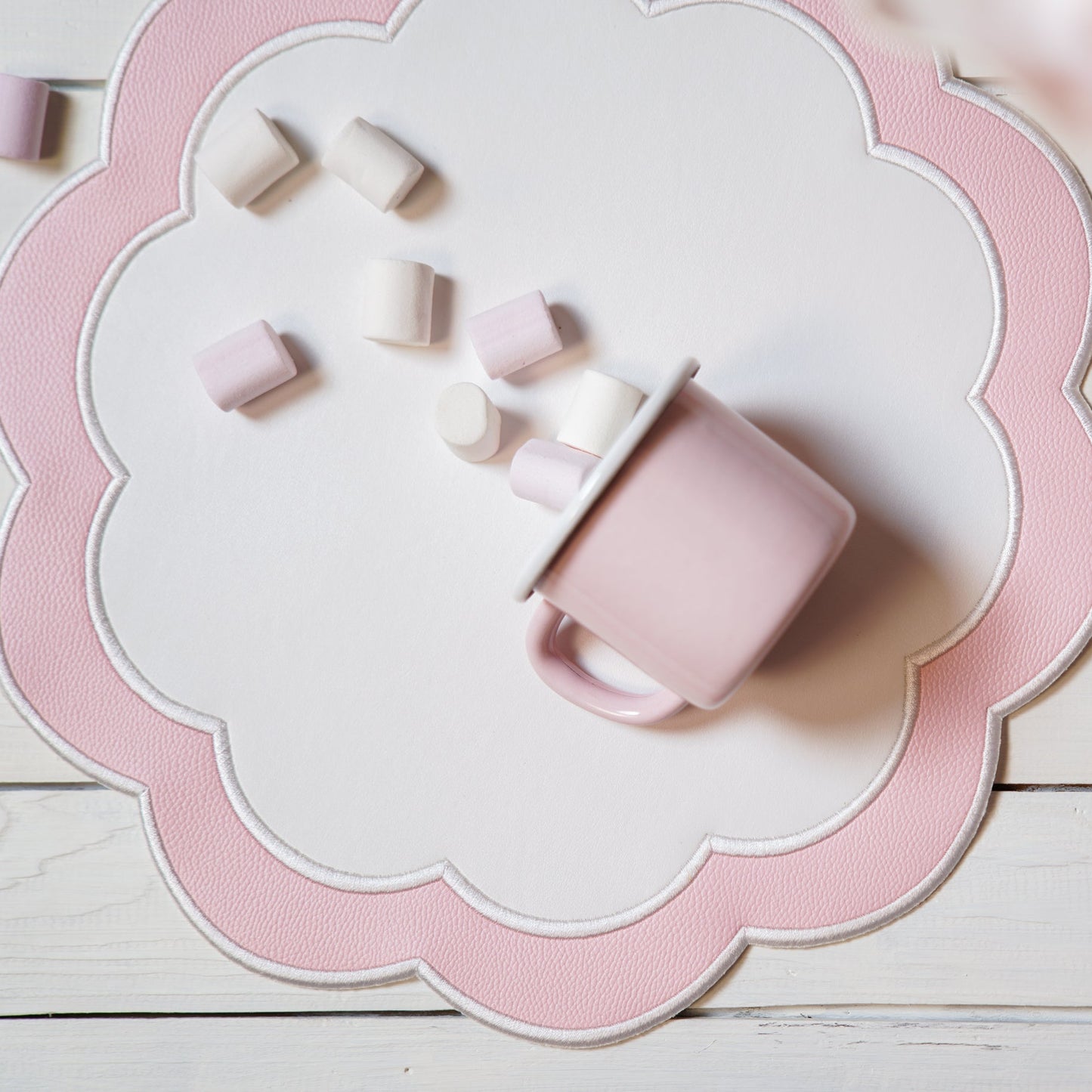 Pink ceramic mug with scattered pieces on a decorative pink and white plate.
