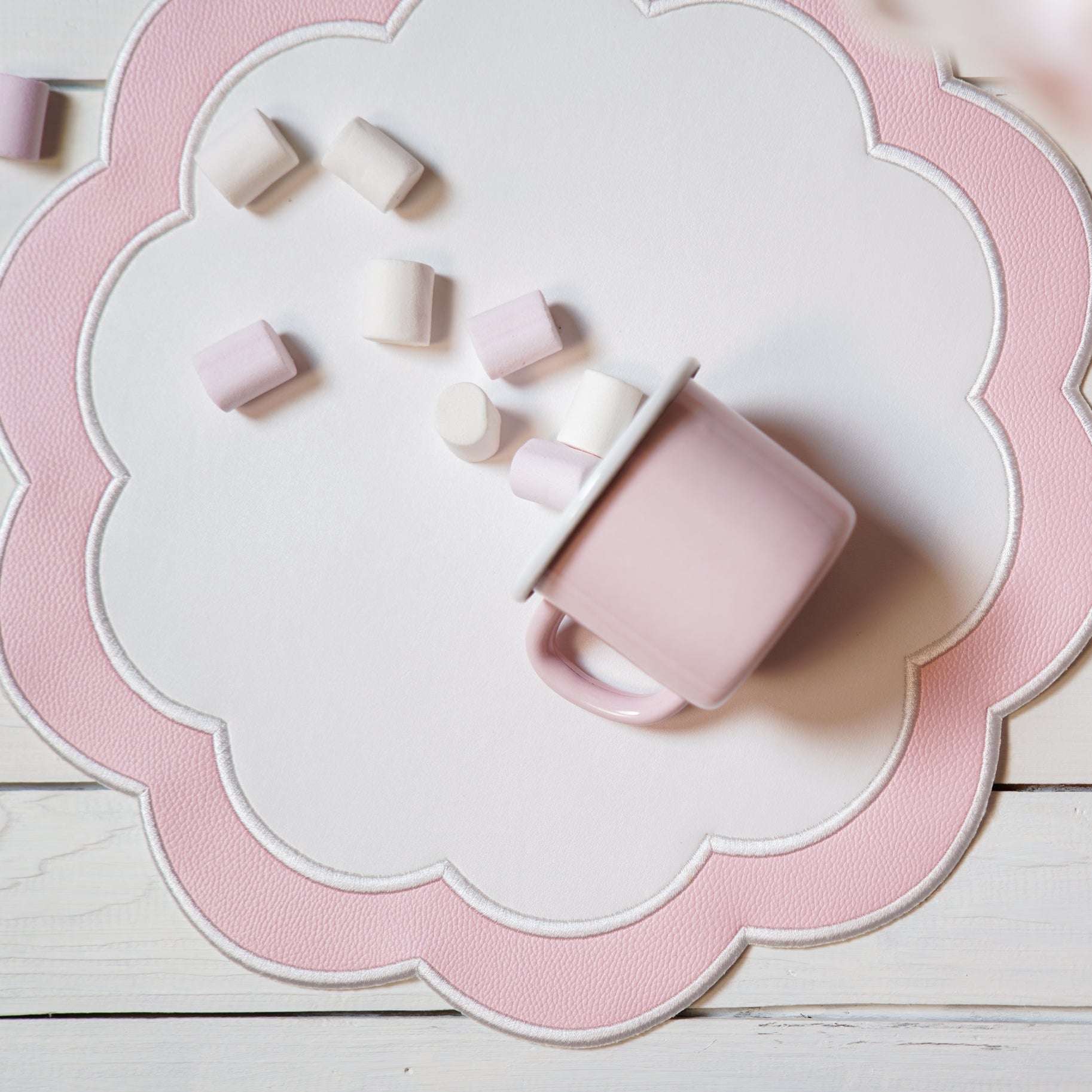 Pink ceramic mug with scattered pieces on a decorative pink and white plate.