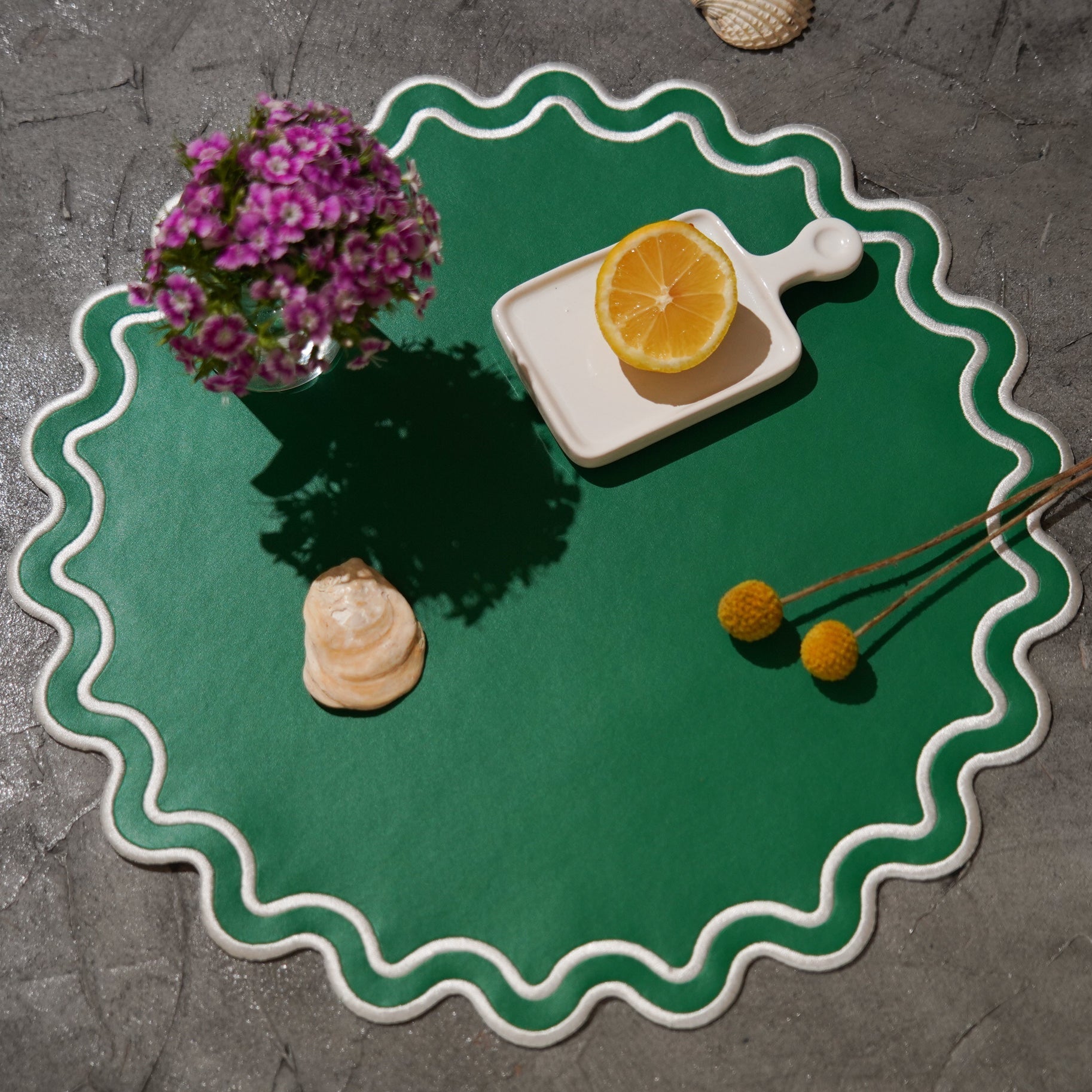 Green placemat with decorative elements on a gray surface