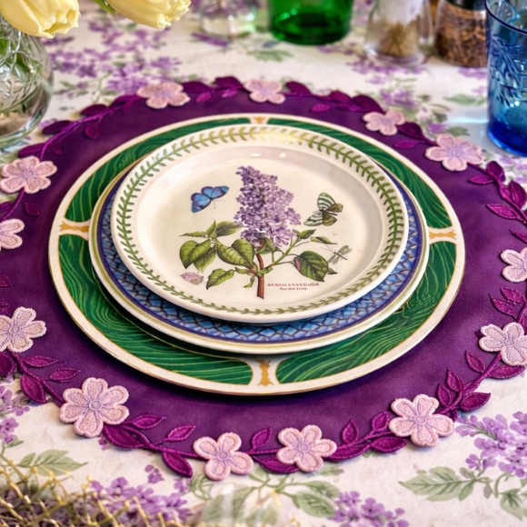 Decorative table setting with floral plates and a purple placemat.