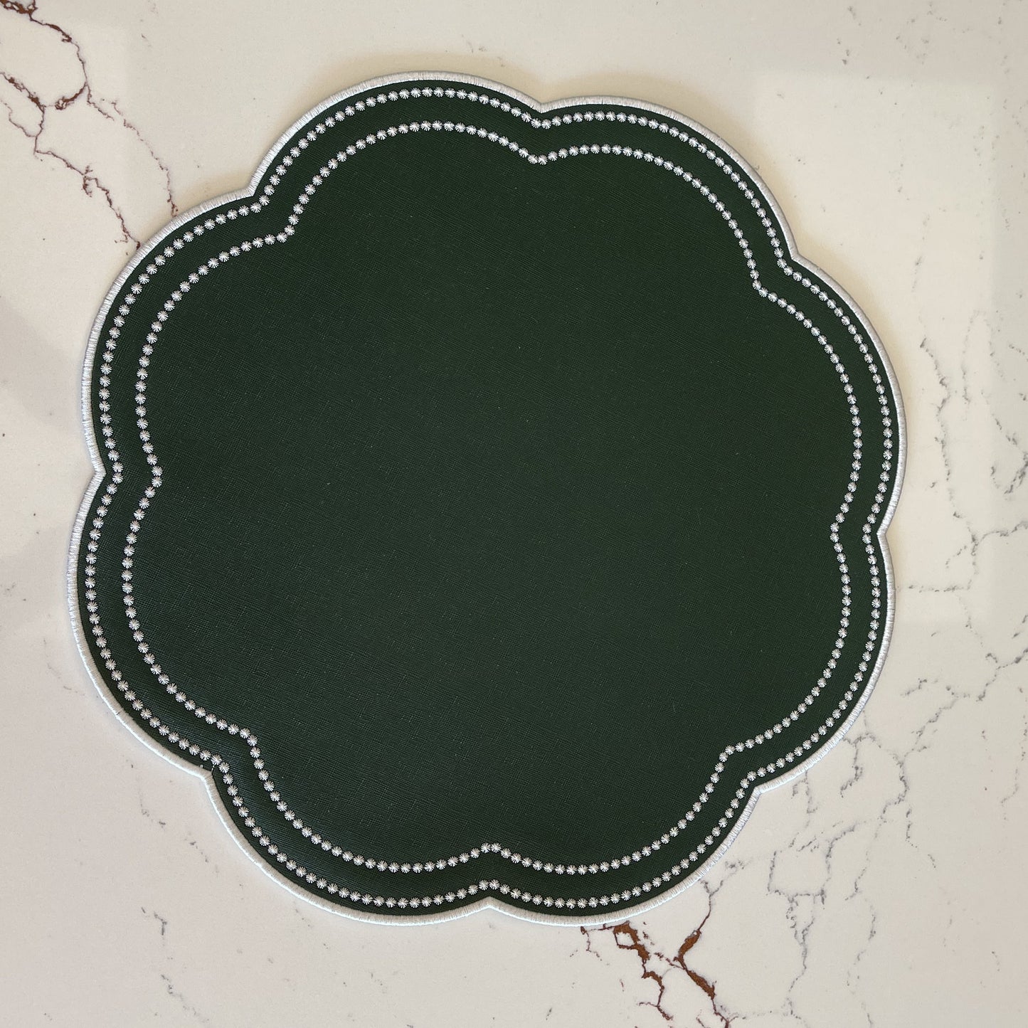 Decorative dark green label with white border on a marble surface