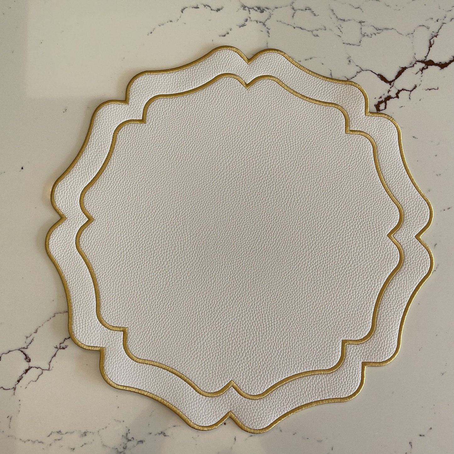 Decorative white plate with gold rim on a marble surface