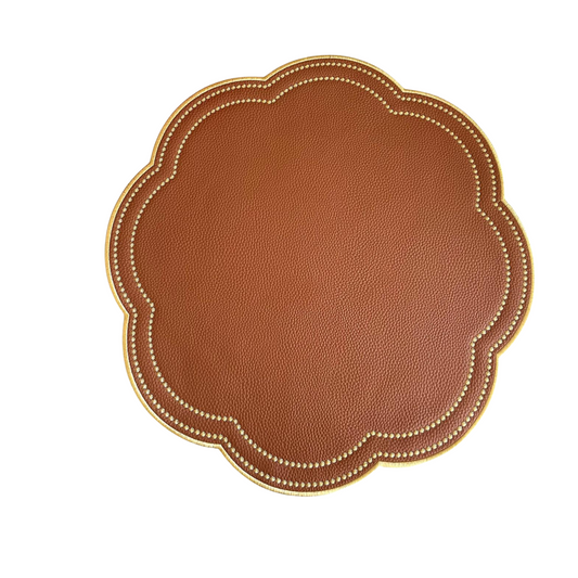 Round brown faux leather placemat with a scalloped edge and gold accents around the border.