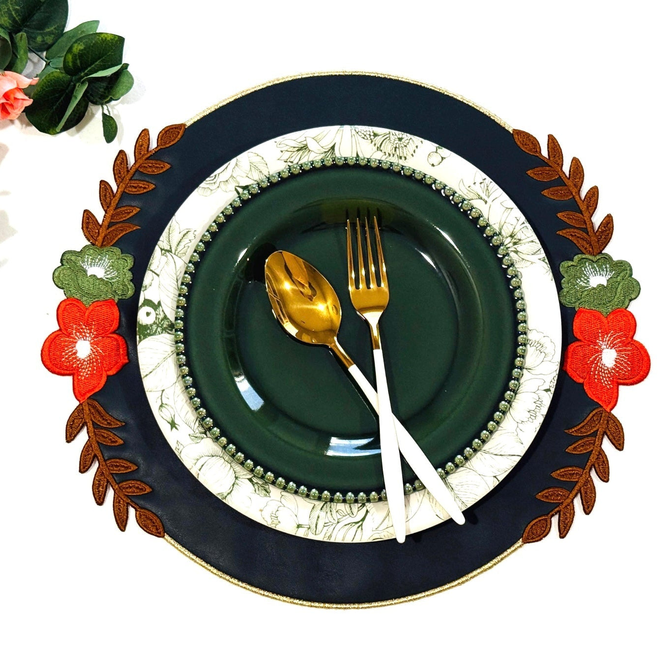 A dark green faux leather placemat with a decorative edge, presented on a table setting with a plate and cutlery.