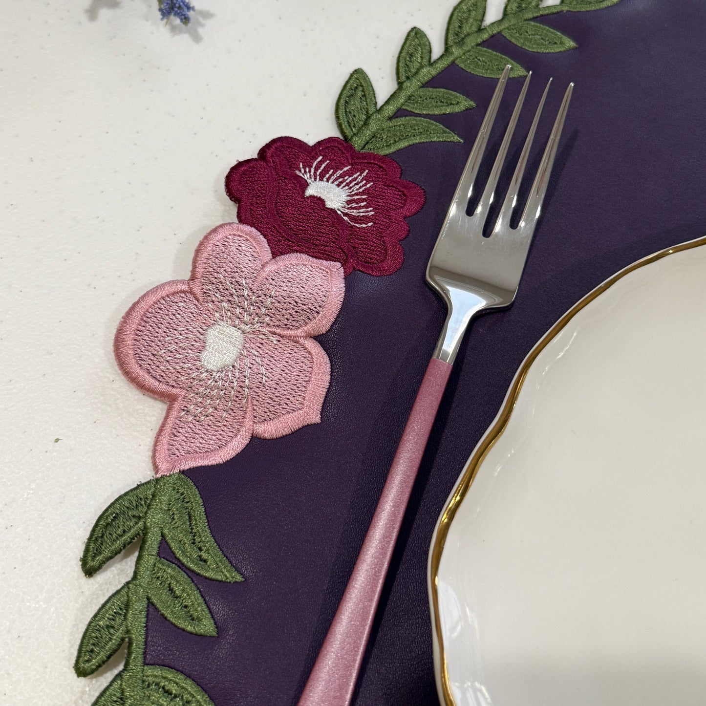Decorative floral mat with flowers and leaves on a white surface