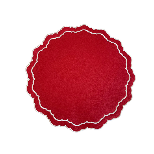 A round, red faux leather placemat with a scalloped edge design on a white background.