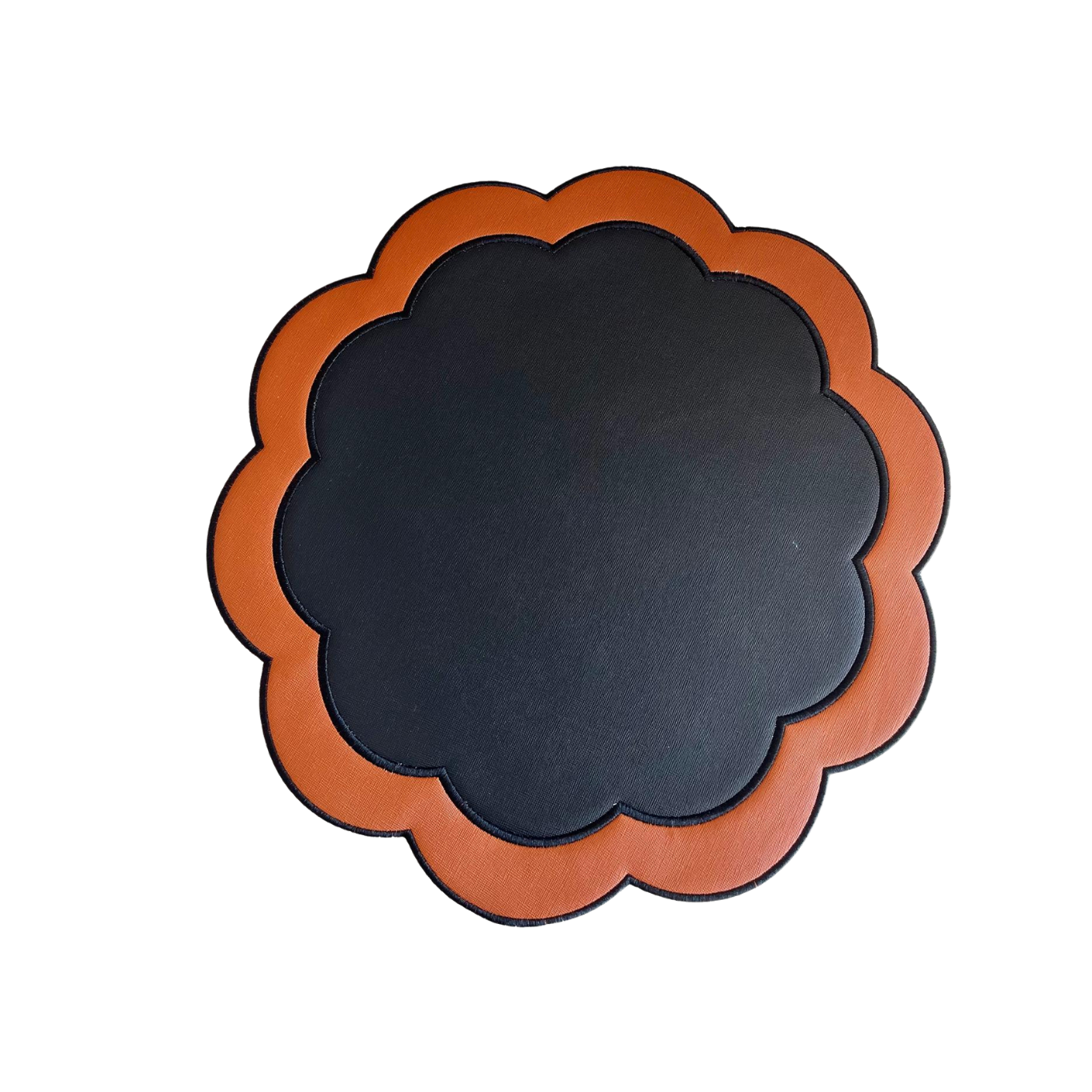 A round black faux leather placemat with an orange border and embroidered details.