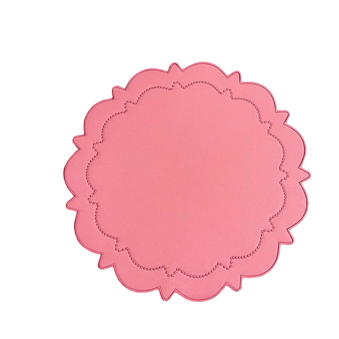 A round pink faux leather placemat with a scalloped edge design.