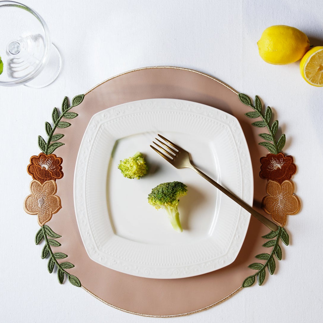 White plate with broccoli, lemon, and a fork on a white surface