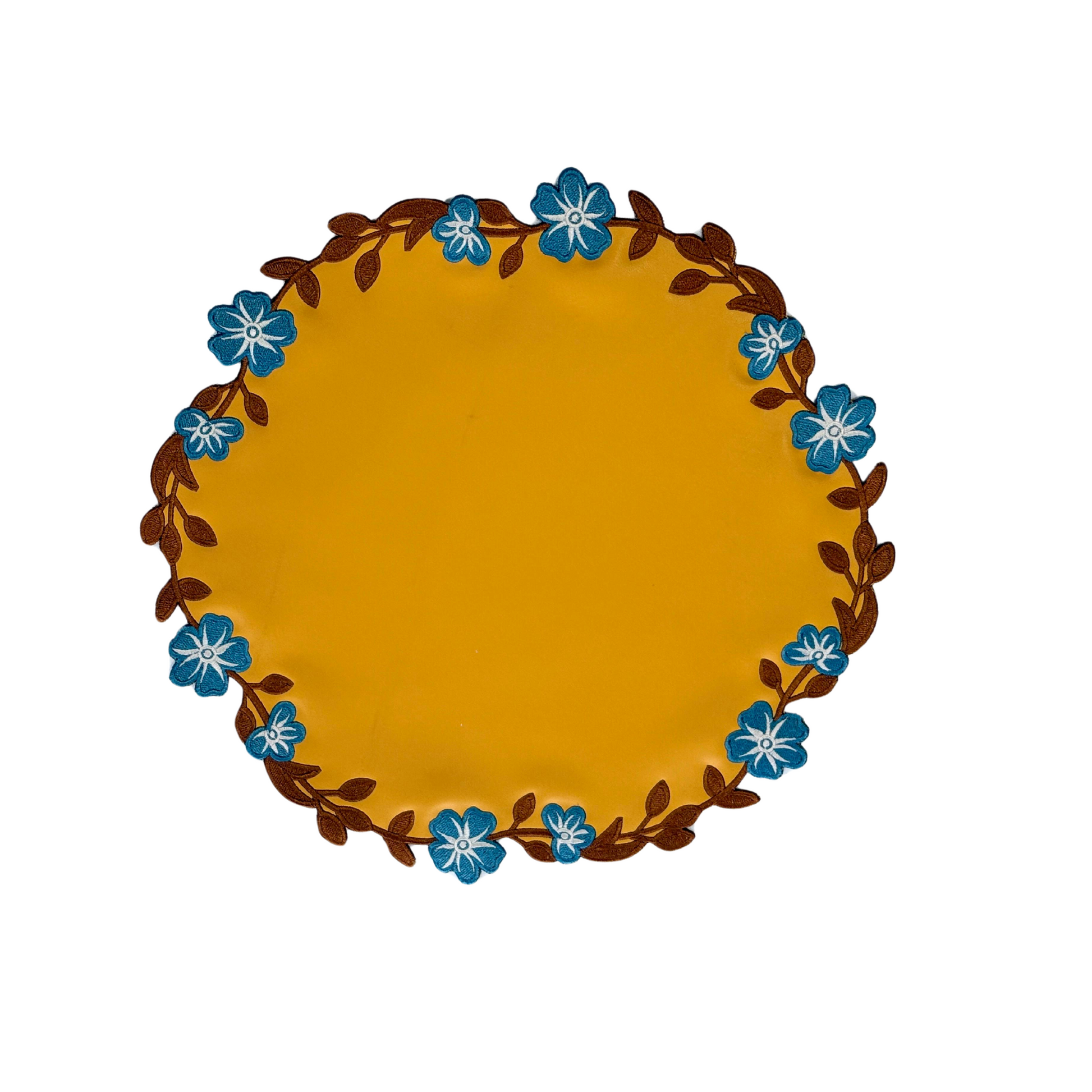 A round Unity yellow faux leather placemat with blue floral embroidery around the edge, displayed on a white background.