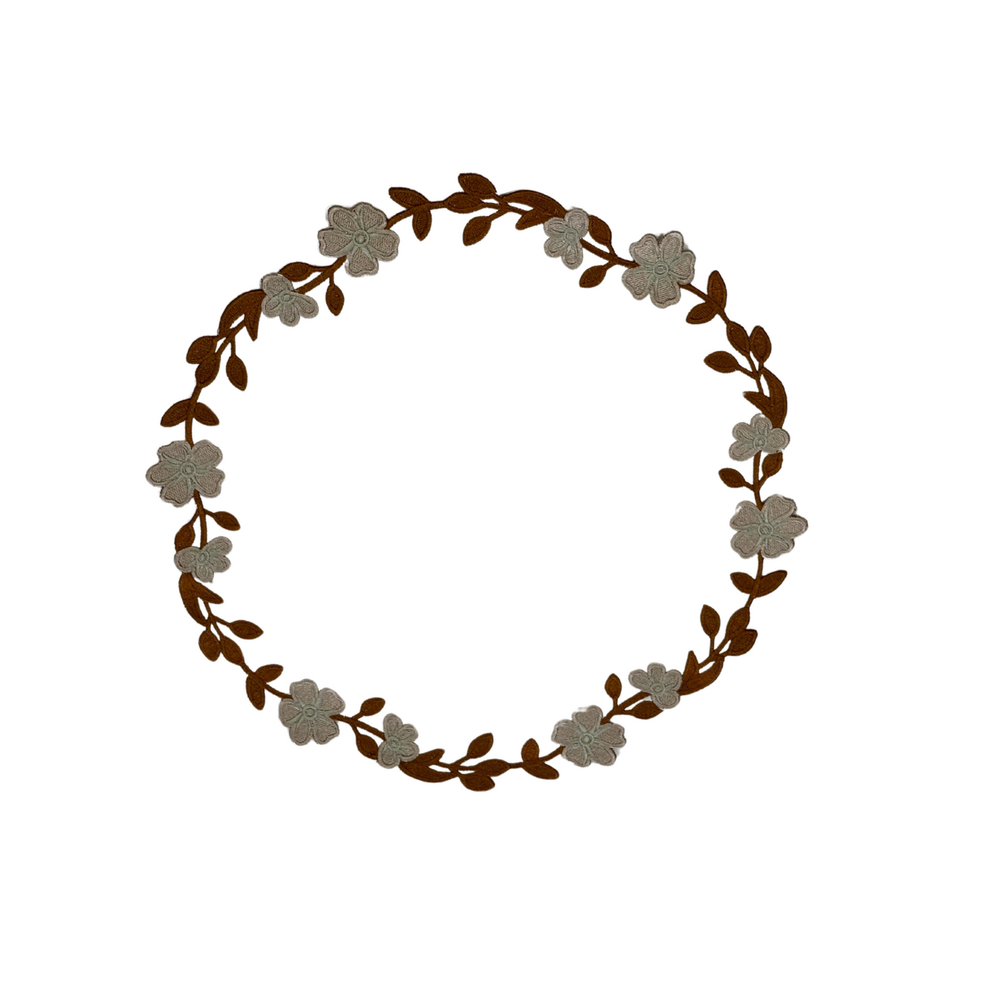 A round faux leather placemat with a floral pattern in white and brown colors.
