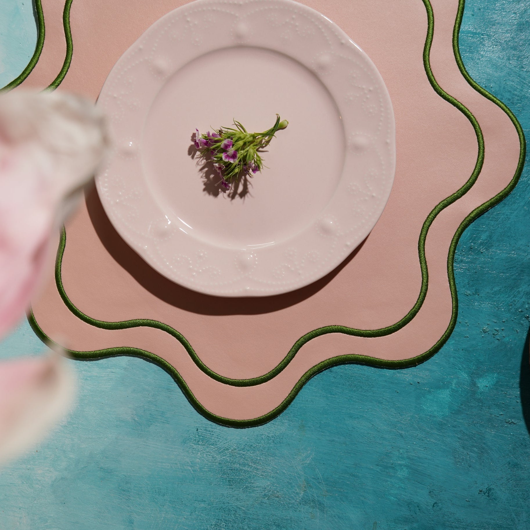 Pink plate with purple flowers on a colorful abstract background
