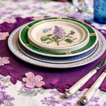 Decorative table setting with floral plates and a purple placemat.