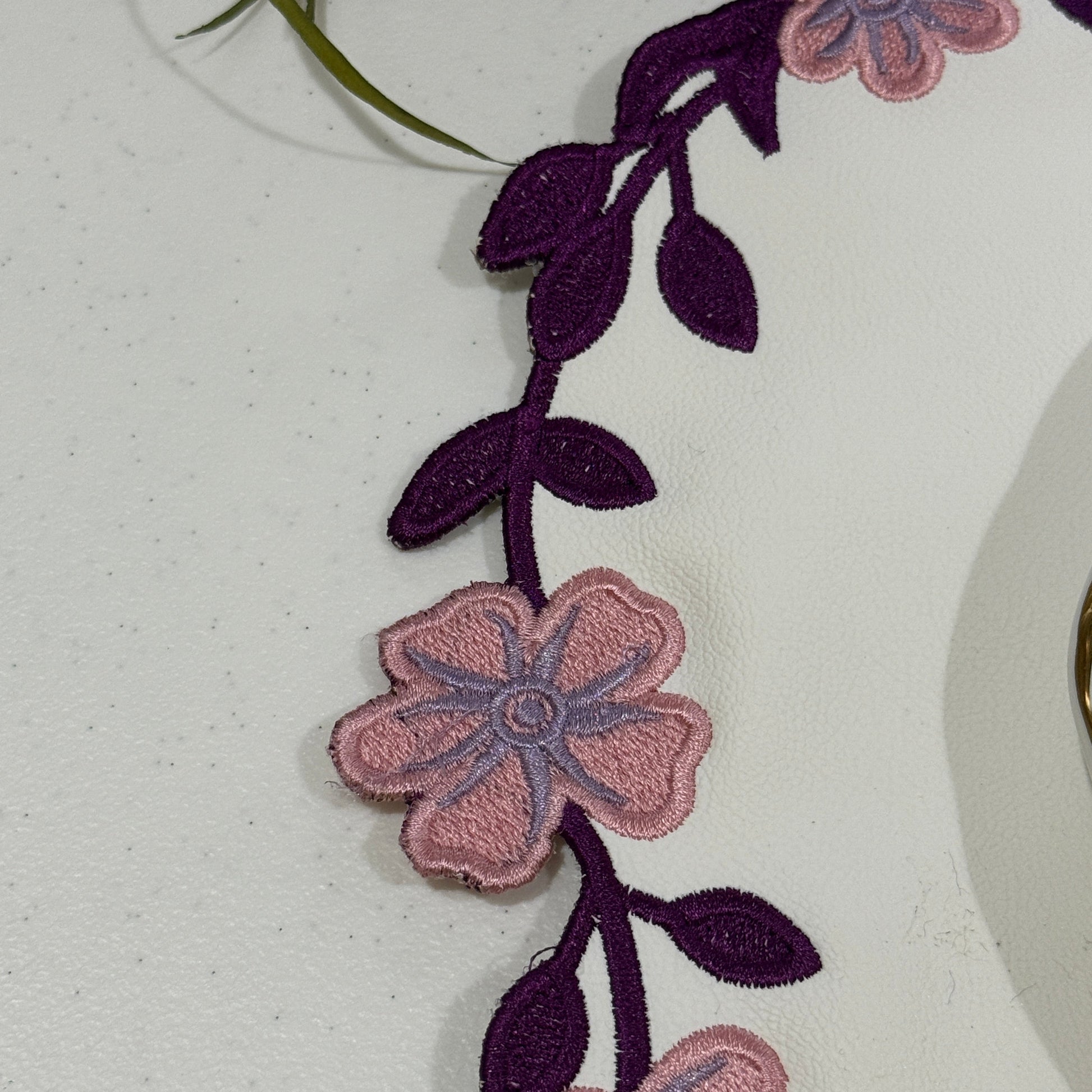 Close-up of floral embroidery on a garment with a white background