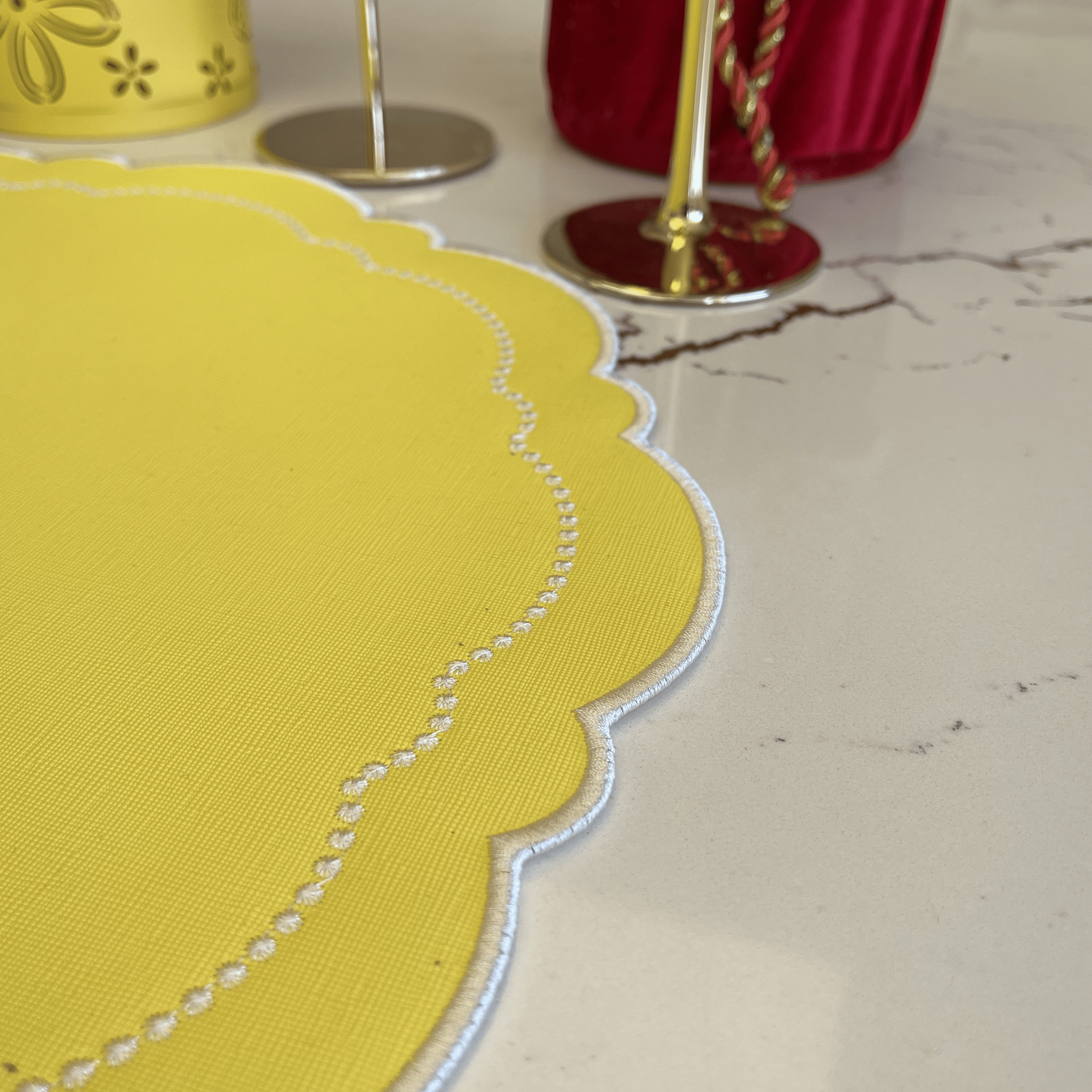 Yellow decorative item with a scalloped edge on a marble surface