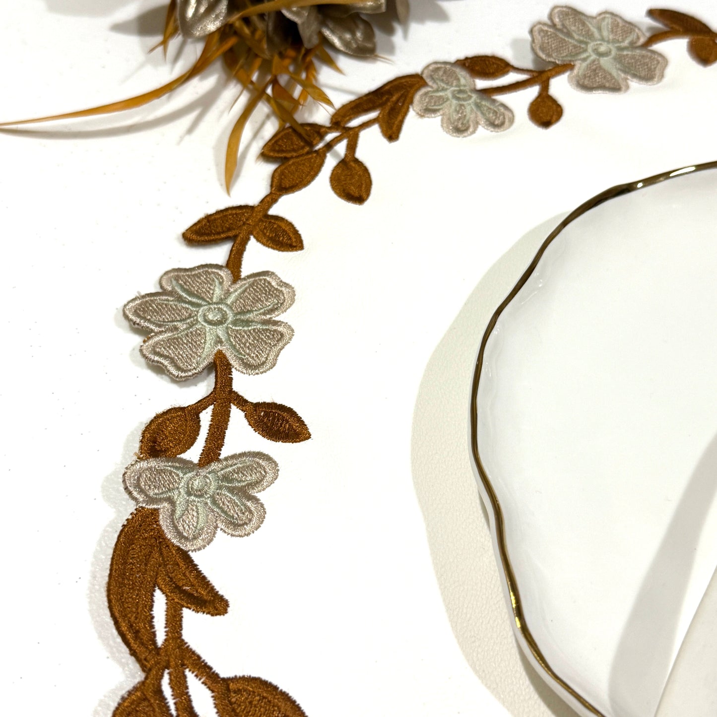 Decorative floral ribbon with gold and silver flowers on a white background